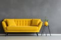 Yellow sofa and decorative home decor accent pieces against grey and yellow wall with copy space