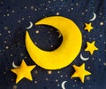 Yellow soft month-pillow with small soft stars on a dark blue background