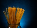 yellow spaghetti macaroni stands in a glass jar on a dark background Royalty Free Stock Photo