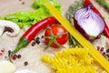 Yellow spaghetti pasta and bright summer vegetables onion, garlic, tomato, pepper, rosemary and champignon mushroom on table Royalty Free Stock Photo