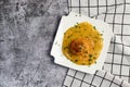 Yellow split pea puree with meatball on a white square  plate on a dark background Royalty Free Stock Photo