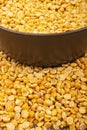 Yellow split peas in a ceramic bowl and grits scattered on a background of coarse-textured burlap. Traditional cereals for making Royalty Free Stock Photo