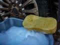 Sponge and bucket of soapy water to wash down an alloy wheel Royalty Free Stock Photo