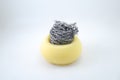 Yellow sponge with metal scrubber on top for dishwashing