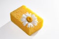Yellow sponge for washing dishes and cleaning on a white background, camomile