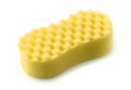 Yellow sponge for washing dishes on a white background. The sponge has a knurled surface. It can be used for household and car