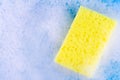 yellow sponge in white bubble foam for dish wash. Washcloth covered in soap. Domestic chores and supplies concept. Sensitive