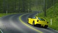 Yellow sports car driving around a bend with empty forest road ahead. 3D rendering