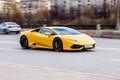 Yellow sports car Lamborghini Huracan is driving down the street. Front side view of fast moving supercar car on the road Royalty Free Stock Photo