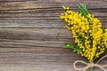 Yellow spring Mimosa bouquet with bow on a rustic wooden background with copyspace Royalty Free Stock Photo