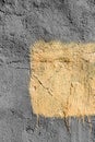 Yellow square with peeling paint on gray plastered wall background. Grunge texture. copy space