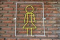 Yellow steel coil signs, female toilet symbols on brick walls, background