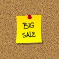 Yellow stick note paper with words BIG SALE pinned on cork board