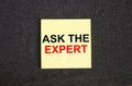 Yellow sticker on the dark gray texture background with text Ask The Expert Royalty Free Stock Photo