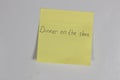 Yellow sticker on the refrigerator door with an inscription Dinner on the stove magnet Royalty Free Stock Photo