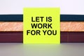 Yellow sticker with text Let Is Work For You on a stack of notebooks Royalty Free Stock Photo