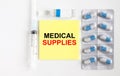 Yellow sticker with text Medical Supples on a white background with syringes, pills and ampoule Royalty Free Stock Photo