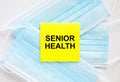 Yellow sticker with text Senior Health lying on the masks