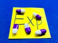 Capsules arranged over 'exp' on a sticky note hint at expired medicine and health caution Royalty Free Stock Photo