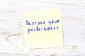 Yellow sticky note with handwritten text improve your performance Royalty Free Stock Photo