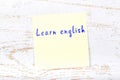 Yellow sticky note with handwritten text learn english