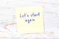 Yellow sticky note with handwritten text lets start again