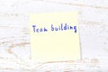 Yellow sticky note with handwritten text team building
