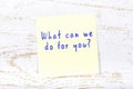 Yellow sticky note with handwritten text what can we do for you Royalty Free Stock Photo