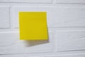 Yellow sticky note isolated on a background white brick wall Royalty Free Stock Photo