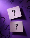 Paper notes with question marks on purple background, flat lay. Space for text Royalty Free Stock Photo