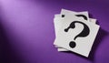 Paper notes with question marks on purple background, flat lay. Space for text Royalty Free Stock Photo