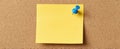 The yellow sticky note pinned on a corkboard surface for reminders.AI generated image Royalty Free Stock Photo