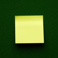 Yellow sticky note placed on a textured green surface, possibly fabric or felt. The note Royalty Free Stock Photo