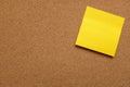 Yellow sticky note stuck on cork board Royalty Free Stock Photo