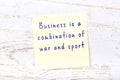 Yellow sticky note on wooden wall with wise quote