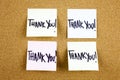 A yellow sticky note writing, caption, inscription with text Thank you, in black ext on a sticky note pinned to a cork Royalty Free Stock Photo