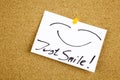 A yellow sticky note writing, caption, inscription Top view of Just Smile sticky note pasted in black ext on a sticky Royalty Free Stock Photo