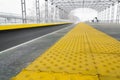 Yellow stop line for blind people at railroad station in perspective