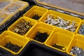 Yellow storage case with screws, nuts, bolts, nails and other small tools for handyman, close up Royalty Free Stock Photo