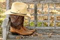 Yellow Straw Cowboy Hat and Brown Ostrich Boots on Weathered Wooden Bench