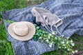 Yellow straw hat, flowers bouquet, a camera and knitted bag lays on grey beach mat on the grass outdoor, isometric view Royalty Free Stock Photo