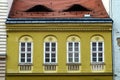 yellow stucco residential apartment building elevation closeup. wood windows and roof dormers Royalty Free Stock Photo