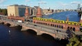 Yellow subway passes over red brick bridge. Great aerial view flight