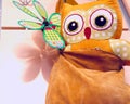 Yellow suede bag hanging on a hanger with a toy inside owls,