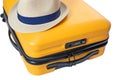 yellow suitcase with a combination lock with numbers 666 on it. Summertime - travel bag and straw hat on top Royalty Free Stock Photo