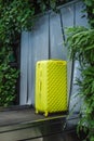Yellow suitcase luggage check-In tape at the airport in green leaves