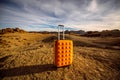 Yellow suitcase on the rocky desert