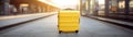 Yellow suitcase into the train station with a train blurred in the background at sunset. Generative AI