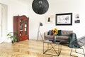 Yellow sunflowers on a black, marble coffee table and framed art on a tall white wall in an elegant living room interior.