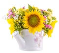 Yellow sunflowers and colored wild flowers in a white sprinkler, close up